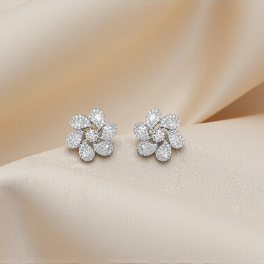Pair of diamond earrings on a soft beige fabric background