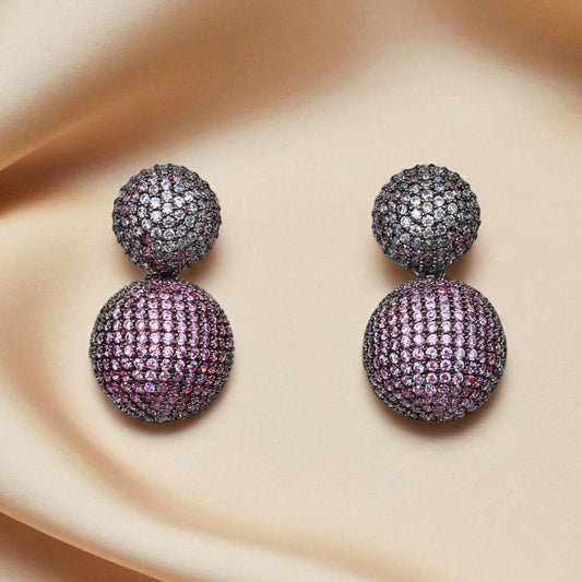 Purple gemstone earrings on a beige fabric background