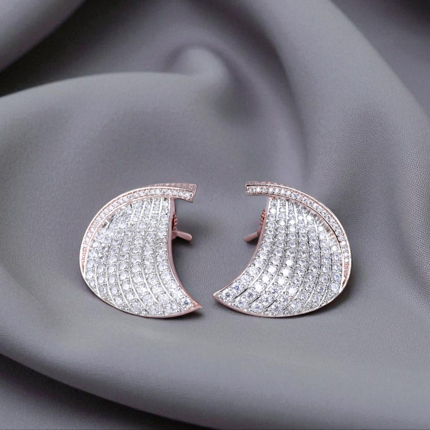 Pair of diamond earrings on a gray fabric background