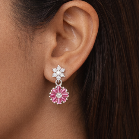 Close-up of a woman wearing pink floral earrings against a beige background