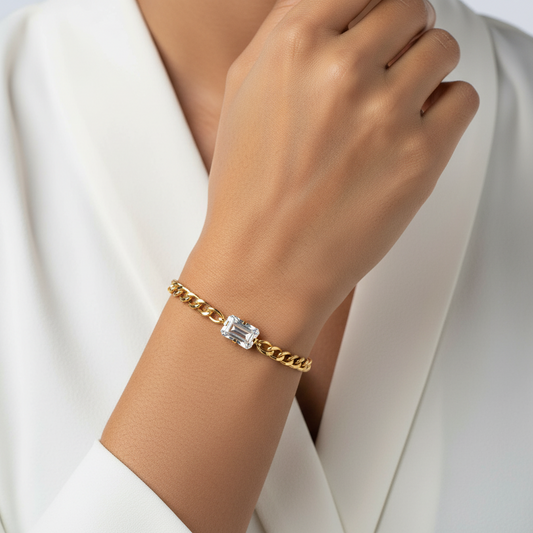 Gold bracelet with a diamond on a wrist against a white background