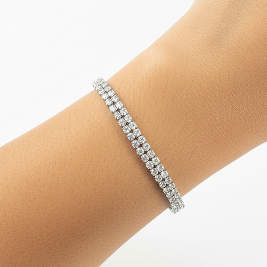 Silver bracelet on a wrist with a purple fabric background