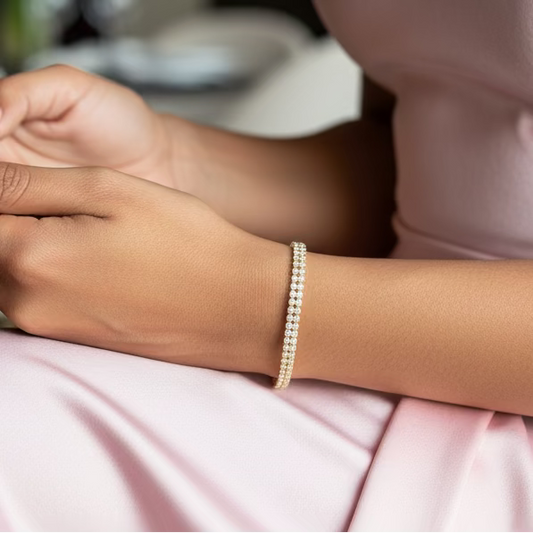 Gold bracelet on a wrist with a purple and gray background