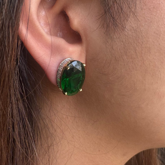 Close-up of an ear wearing a green gemstone earring.