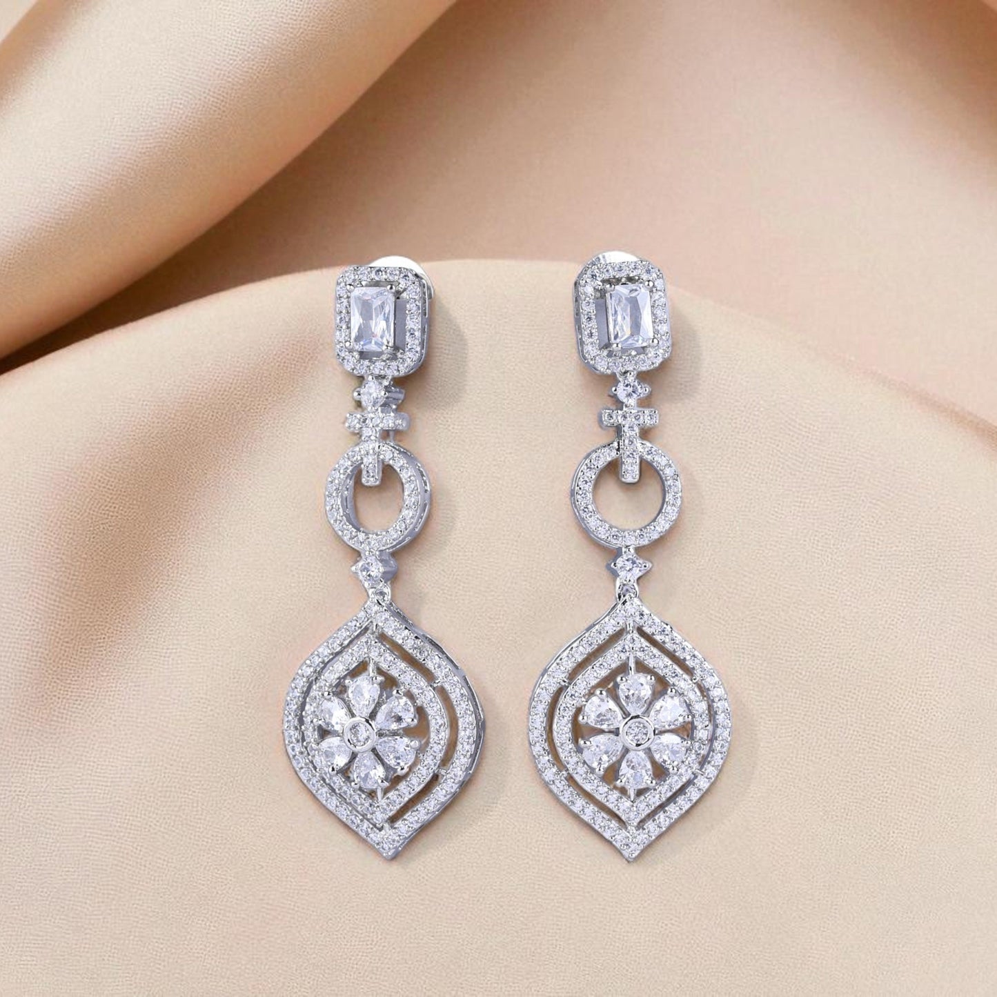 Pair of diamond earrings on a soft fabric background