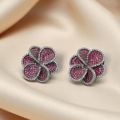 Pair of pink gemstone earrings on beige fabric