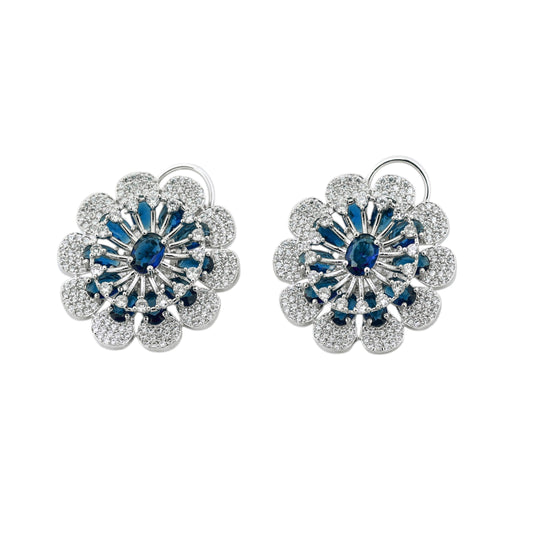 Pair of floral earrings with blue gemstones on a white background