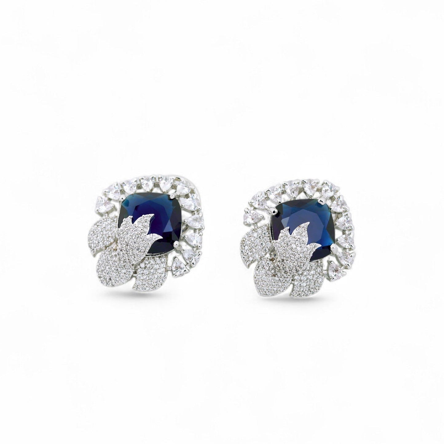 Pair of earrings with blue gemstones and diamond-like stones on a white background