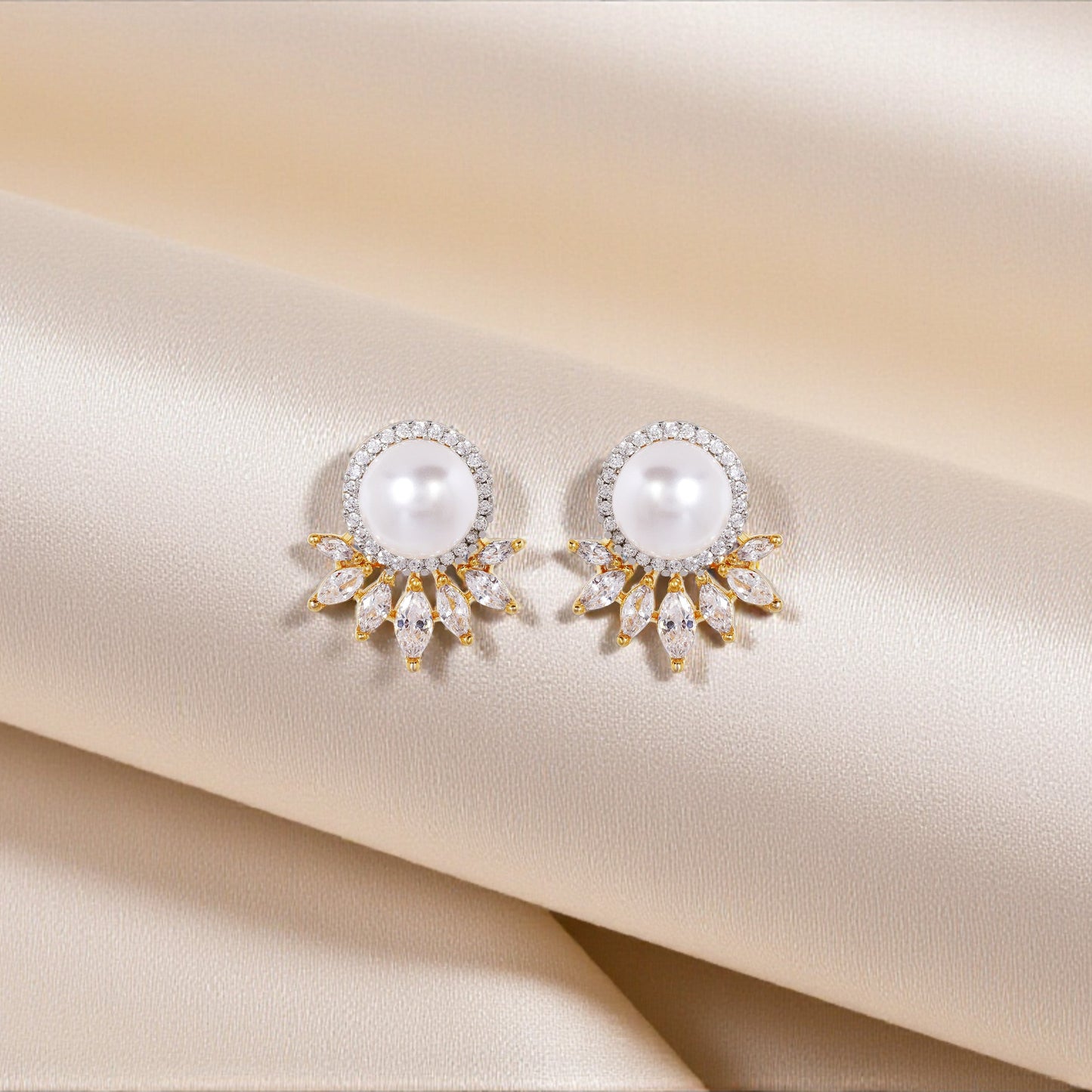 Pair of pearl earrings on a satin surface