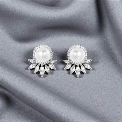 Pair of pearl earrings on a gray fabric background