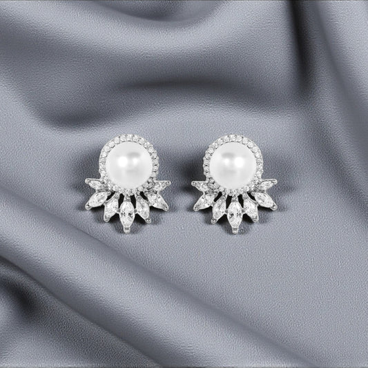 Pair of pearl earrings on a gray fabric background