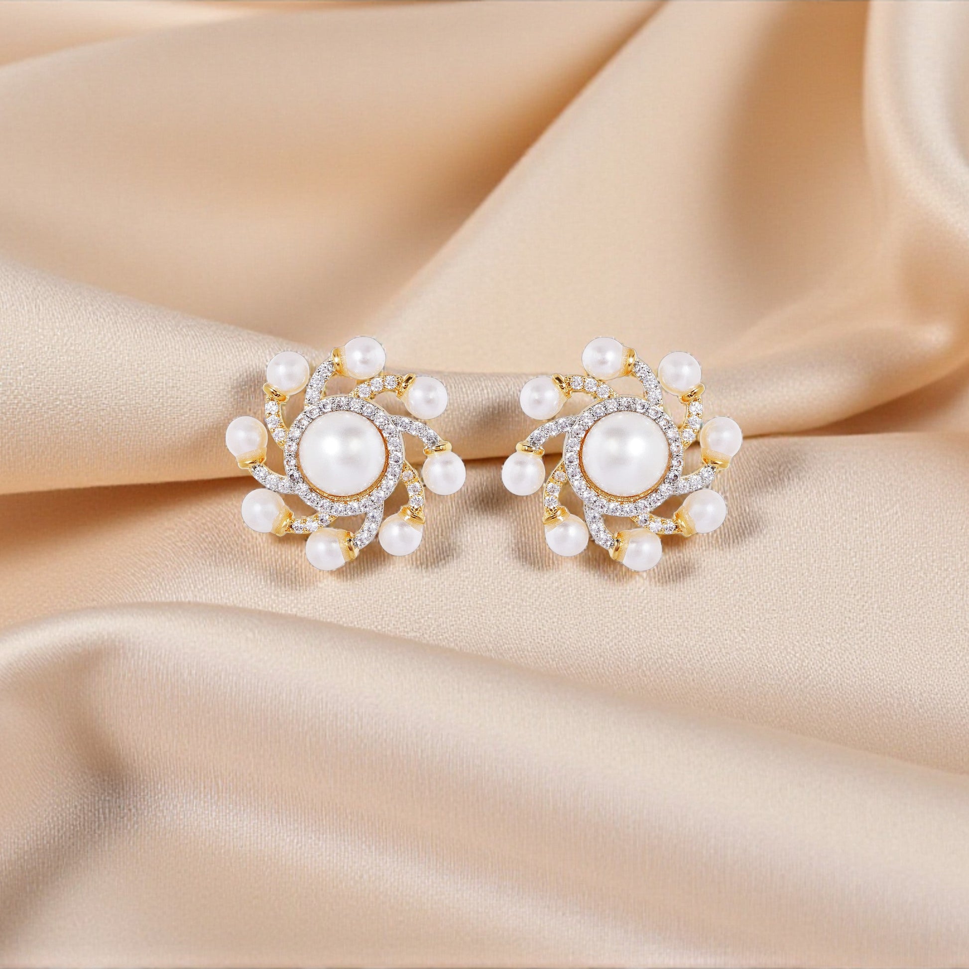 Pearl earrings on a beige satin background