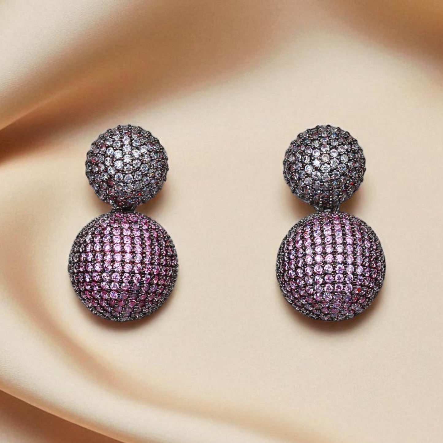 Purple gemstone earrings on a beige fabric background