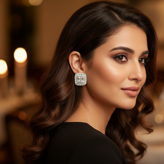 Pair of square-shaped earrings with clear gemstones on a white background