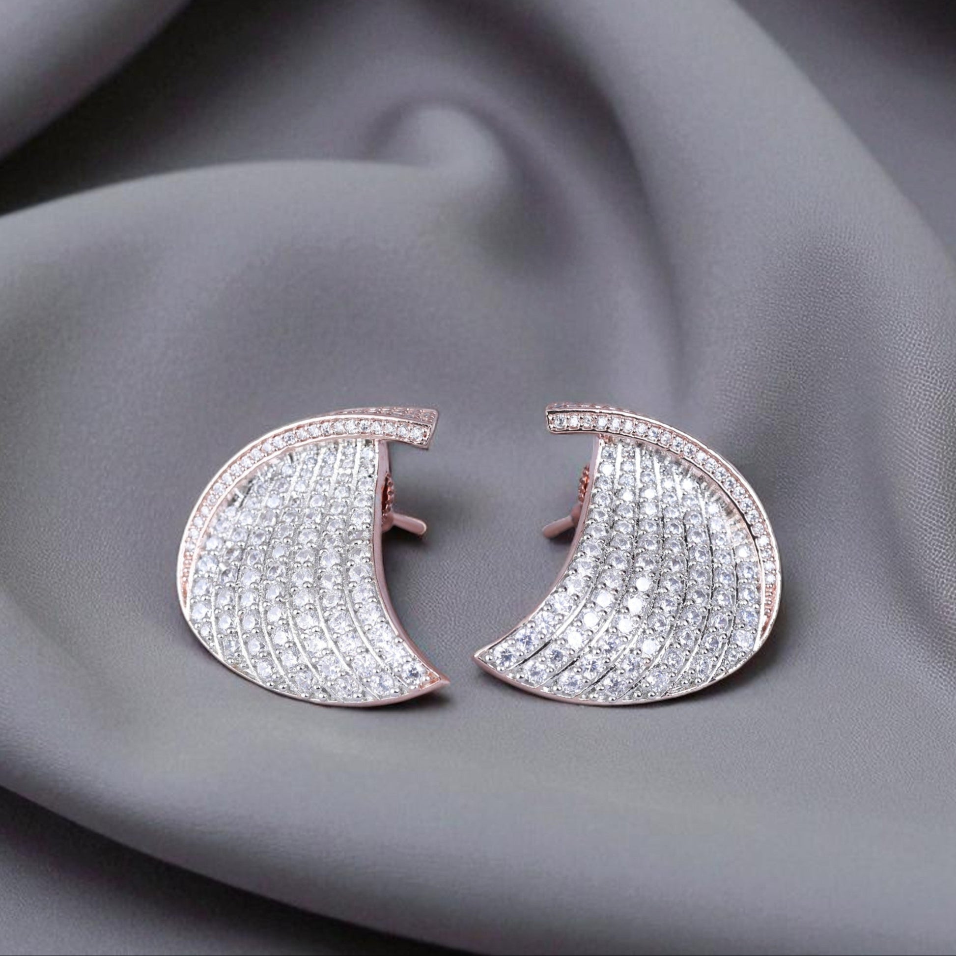 Pair of diamond earrings on a gray fabric background