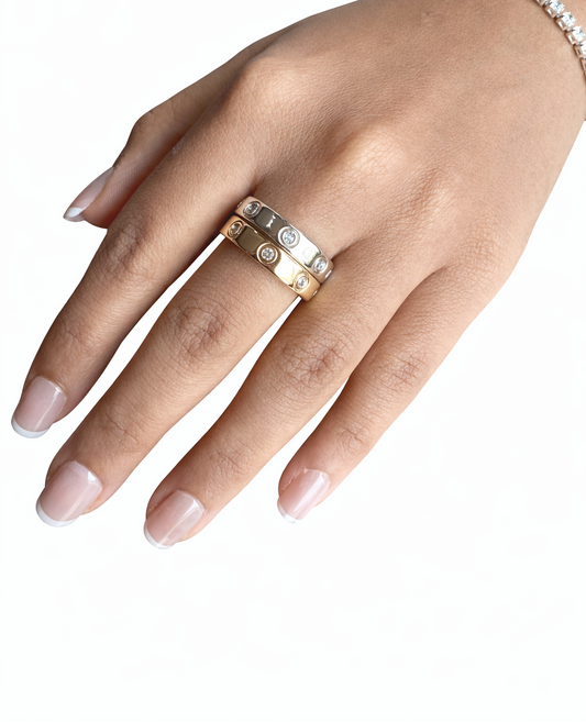 Hand wearing a gold ring on a white background
