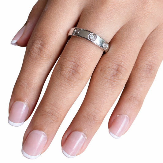 Hand wearing a silver ring on a white background