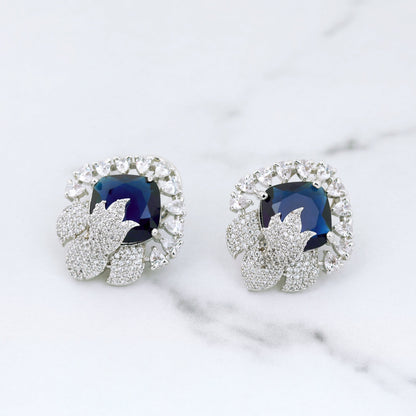 Pair of earrings with blue gemstones on a marble surface