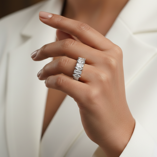 Hand wearing a silver ring with a blurred background