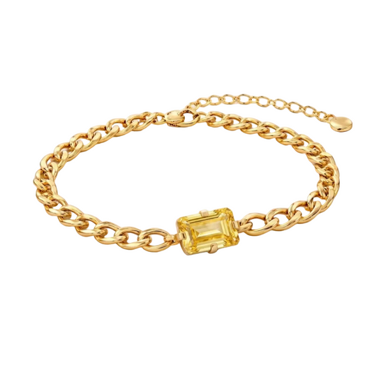 Gold chain bracelet with a yellow gemstone on a white background