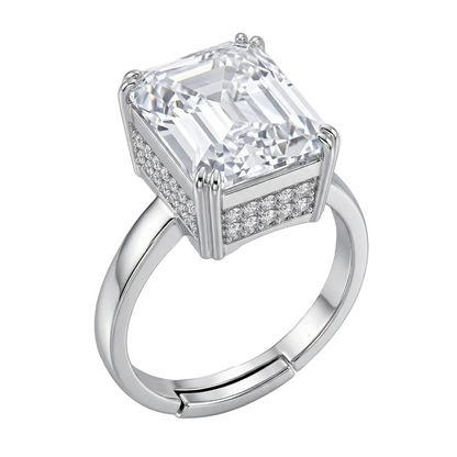 Diamond ring with emerald-cut center stone and smaller diamonds on a white background