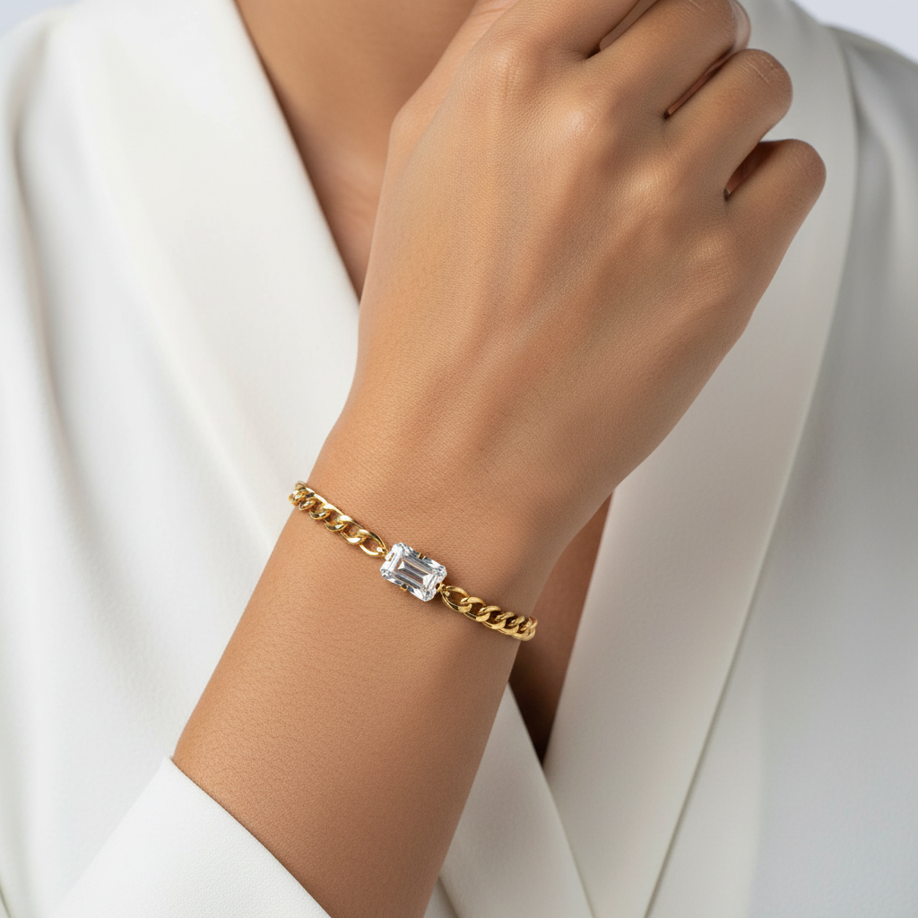 Gold bracelet with a diamond on a wrist against a white background