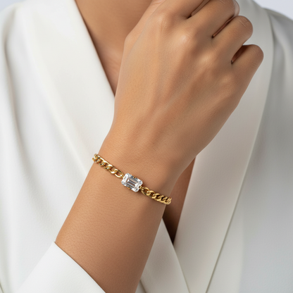 Gold bracelet with a diamond on a wrist against a white background