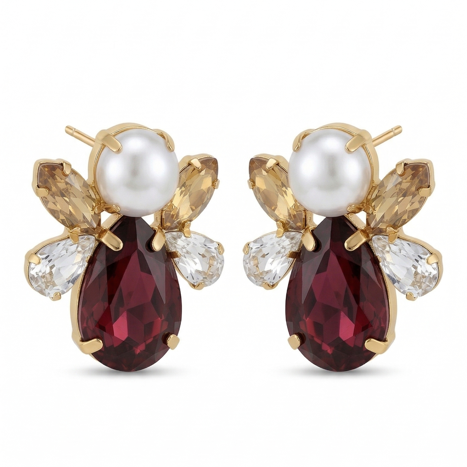 Pair of earrings with red gemstones and pearl-like centers on a white background