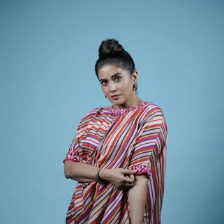 Woman wearing a colorful striped saree against a blue background