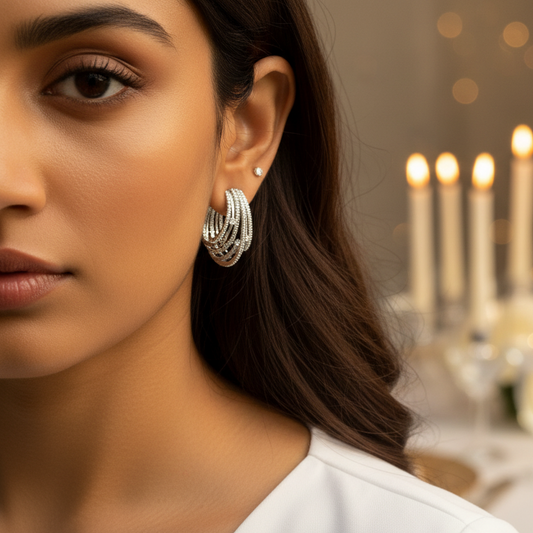 Woman wearing earrings with a blurred background of a dining table with candles