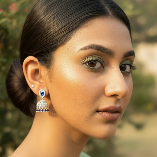 Woman wearing a pair of earrings with a blurred natural background
