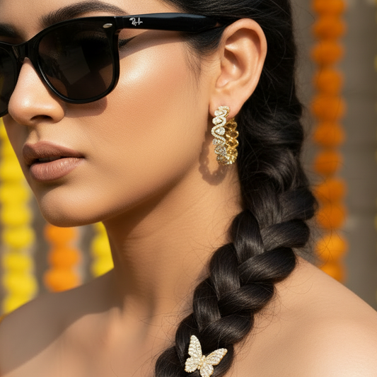 Woman wearing sunglasses and a yellow top with a braided hairstyle against a colorful background