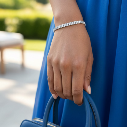 Silver bracelet on a wrist with a purple fabric background