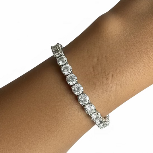 Diamond bracelet on a wrist with a purple fabric background