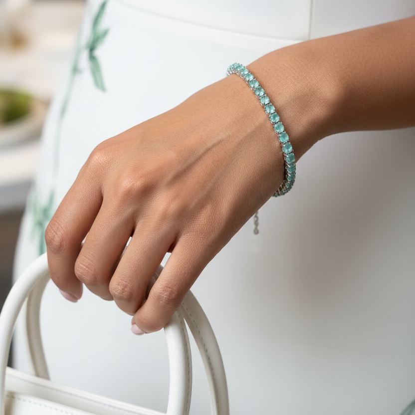 Turquoise beaded bracelet on a wrist against a purple fabric background