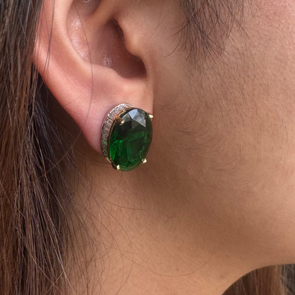 Close-up of an ear wearing a green gemstone earring.