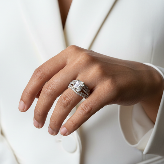 Hand wearing a silver ring with a diamond on a white background