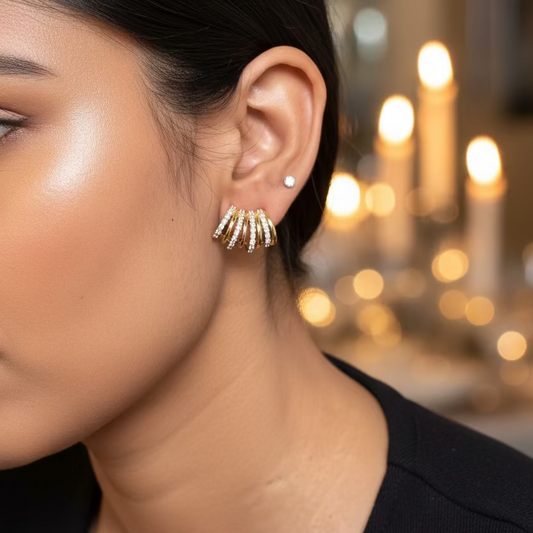 Close-up of an ear wearing gold hoop earrings with a blurred background