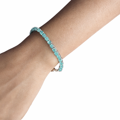 Turquoise beaded bracelet on a wrist against a white background