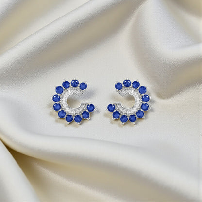 Pair of earrings with blue gemstones on a satin surface